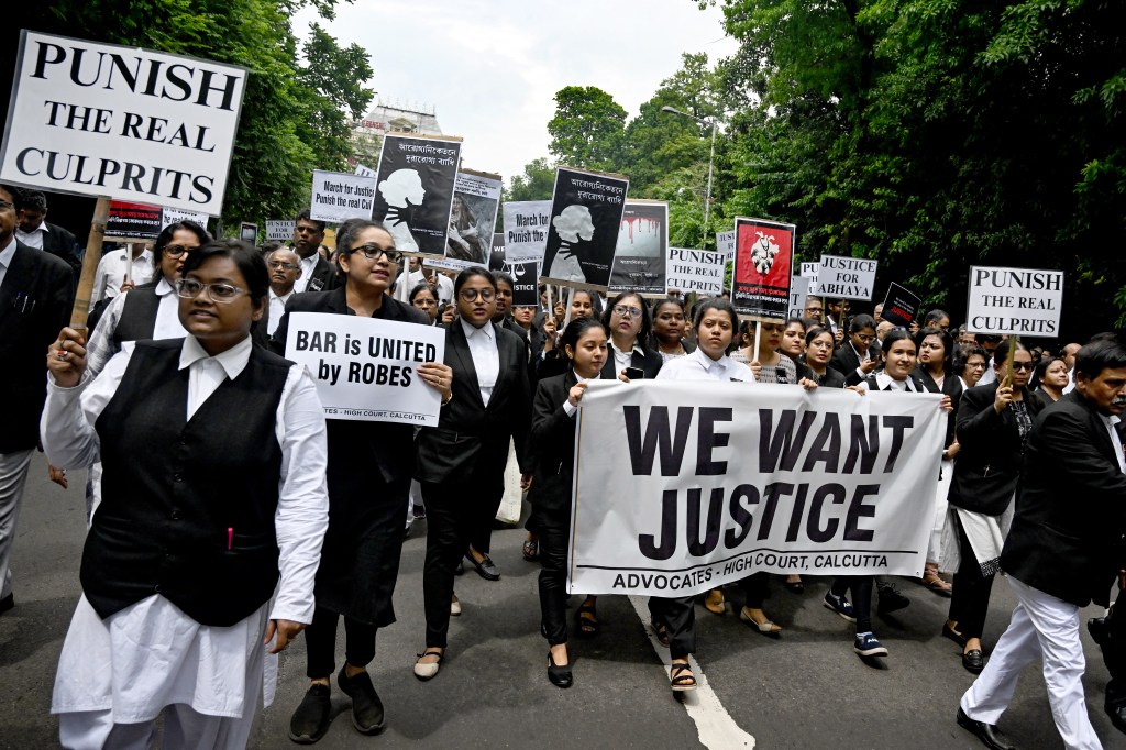 Calcutta High Court advocates hold posters during a protest to condemn the rape and murder of a doctor in Kolkata on August 19, 2024. 