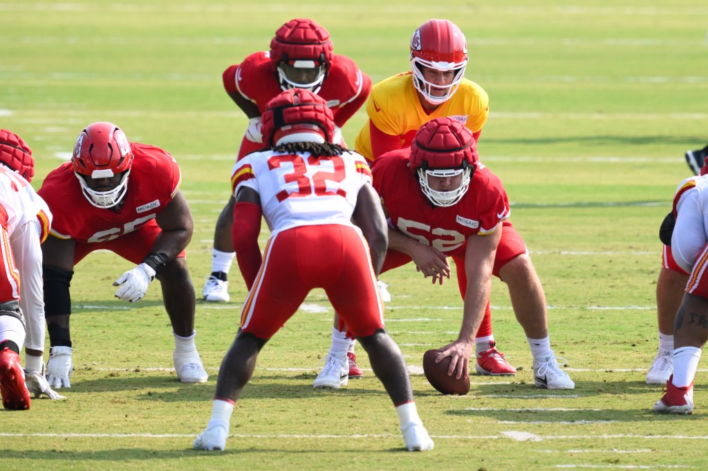 Kansas City Chiefs quarterback Patrick Mahomes, in yellow, prepares to take a snap from Kansas City Chiefs center Creed Humphrey (52) during NFL football training camp Friday, July 26, 2024, in St. Joseph, Mo.